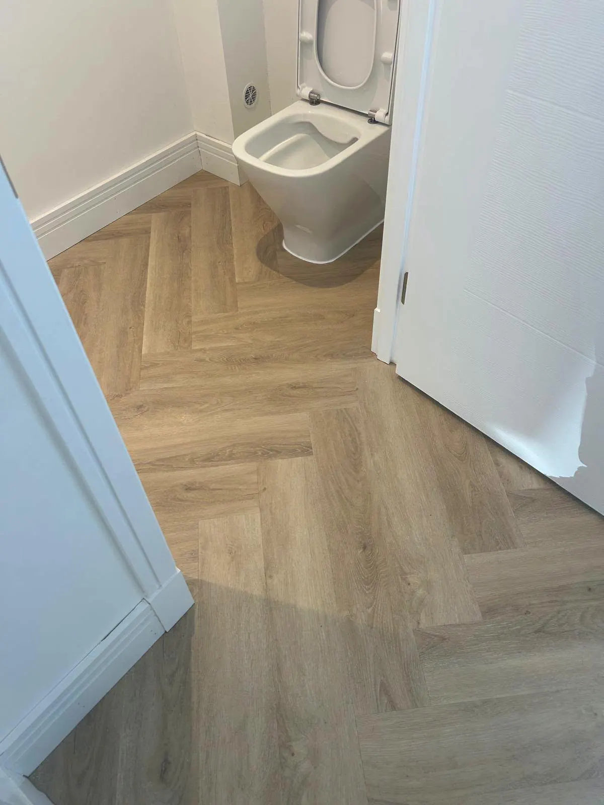 Herringbone flooring fitted in a small bathroom